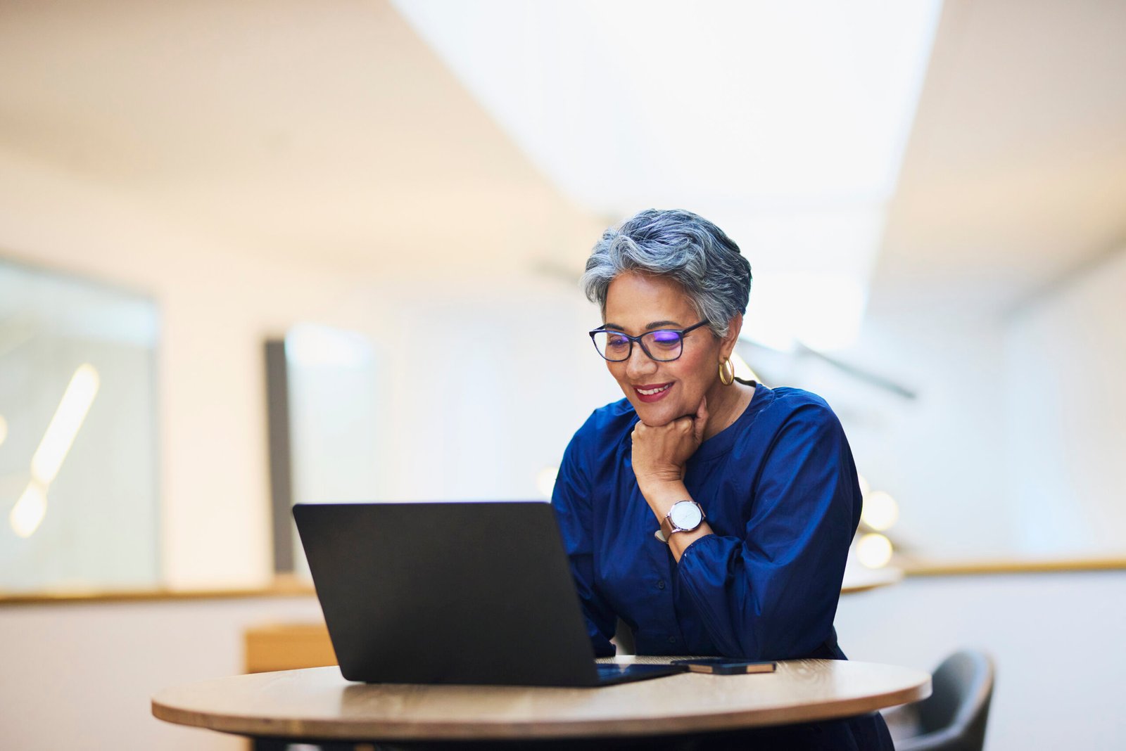 Mature woman smiling at a laptop